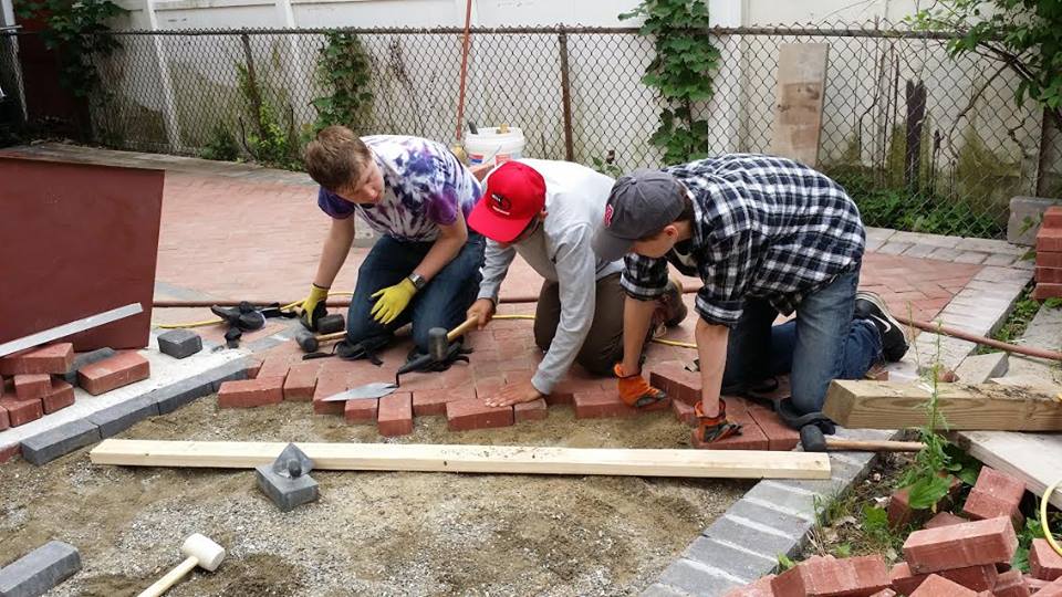 Students laying brick patio